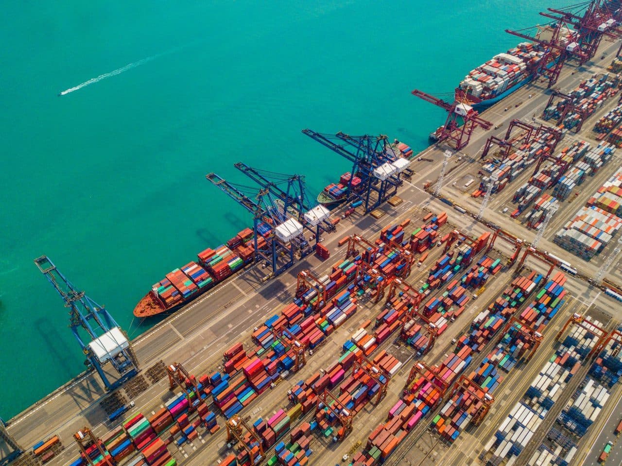 Overhead view of a container terminal with stacked containers and a ship at berth